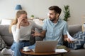 Stressed unhappy couple arguing about expenses with laptop and papers Royalty Free Stock Photo