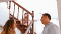 Unhappy young girl watch her parent arguing from the stair. Synchronos Royalty Free Stock Photo