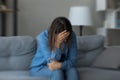 Stressed unhappy young woman sitting on sofa. Royalty Free Stock Photo