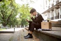 A stressed and upset Asian businessman sits on a staircase after getting fired or losing his job Royalty Free Stock Photo