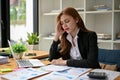 Stressed and upset Asian businesswomanworking on financial reports at her desk Royalty Free Stock Photo