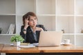Stressed and upset Asian female office worker looking at her laptop screen, pensive Royalty Free Stock Photo