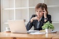 Stressed and upset Asian female office worker looking at her laptop screen, pensive Royalty Free Stock Photo