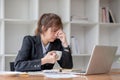 Stressed and upset Asian female office worker looking at her laptop screen, pensive Royalty Free Stock Photo