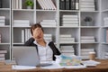 Stressed and upset Asian female office worker looking at her laptop screen, pensive Royalty Free Stock Photo