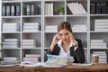 Stressed and upset Asian female office worker looking at her laptop screen, pensive Royalty Free Stock Photo