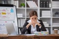 Stressed and upset Asian female office worker looking at her laptop screen, pensive Royalty Free Stock Photo