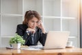 Stressed and upset Asian female office worker looking at her laptop screen, pensive Royalty Free Stock Photo