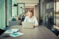 Stressed western businessman using a laptop in living room