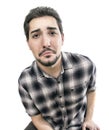 A funny portrait of a stressed whiny man on a white background sorrowly looking in the camera