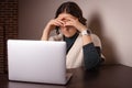 stressed woman covers head with hands, thinking about problems, working online on laptop at home Royalty Free Stock Photo