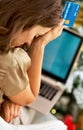 Stressed woman with credit card and laptop in front of chr