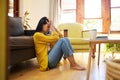 Stressed woman, depression and lonely in the living room sitting on the floor at home. Young sad female suffering from Royalty Free Stock Photo