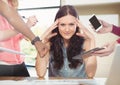 Stressed woman at desk surrounded by technology phone tablet and files