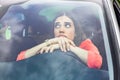 Angry female driver driving a car. Angry young woman stuck in a traffic jam. Woman annoyed in car. Girl stuck in traffic. Royalty Free Stock Photo