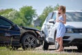 Stressed woman driver talking on mobile phone on street side calling for emergency service after car accident. Road Royalty Free Stock Photo