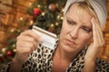 Stressed Woman Holding Credit Card In Front of Christmas Tree Royalty Free Stock Photo