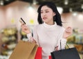 Stressed woman holding credit card and shopping bag at mall Royalty Free Stock Photo