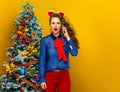 Stressed woman near Christmas tree talking on a cell phone Royalty Free Stock Photo