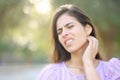 Stressed woman scratching neck in a park