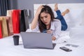 stressed woman using laptop for online shopping on bed, and having problem with blocked credit card Royalty Free Stock Photo