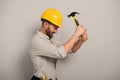 Workman beating yellow helmet with hammer