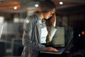 Stressed, worried and tired female entrepreneur typing on a laptop and working overtime late at night. Frustrated and Royalty Free Stock Photo