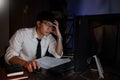 Stressed Young asian business man working late night alone in office late his eyes are gonna closing at table and looking headache Royalty Free Stock Photo