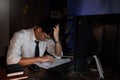 Stressed Young asian business man working late night alone in office late his eyes are gonna closing at table and looking headache Royalty Free Stock Photo