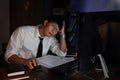 Stressed Young asian business man working late night alone in office late his eyes are gonna closing at table and looking headache Royalty Free Stock Photo