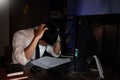 Stressed Young asian business man working late night alone in office late his eyes are gonna closing at table and looking headache Royalty Free Stock Photo