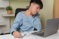 Stressed young Asian businessman massaging stiff shoulder neck when overworked. Exhausted tired man using computer laptop Royalty Free Stock Photo