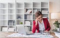 Stressed young Asian businesswoman focuses on rechecking the business financial investment plan& x27;s report at her desk Royalty Free Stock Photo