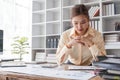 Stressed young Asian businesswoman focuses on rechecking the business financial investment plan& x27;s report at her desk Royalty Free Stock Photo