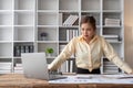 Stressed young Asian businesswoman focuses on rechecking the business financial investment plan's report at her desk Royalty Free Stock Photo