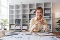 Stressed young Asian businesswoman focuses on rechecking the business financial investment plan& x27;s report at her desk Royalty Free Stock Photo