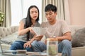 A stressed young Asian couple is planning their savings and managing their household bills together Royalty Free Stock Photo