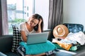 Stressed young Asian female worried about online booking errors or making the wrong travel plans on her summer vacation Royalty Free Stock Photo