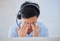 Stressed young asian male call centre agent getting a headache while working on computer in office. Consultant making Royalty Free Stock Photo