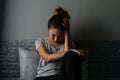 Stressed young Asian woman suffering on depression and sitting alone on bed in dark room at home. Sad, unhappy, disappointed Royalty Free Stock Photo