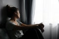 Stressed young Asian woman suffering on depression and sitting alone on bed in dark room at home. Sad, unhappy, disappointed Royalty Free Stock Photo