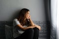 Stressed young Asian woman suffering on depression and sitting alone on bed in dark room at home. Sad  unhappy  disappointed Royalty Free Stock Photo