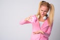 Stressed young blonde nerd woman holding empty piggy bank Royalty Free Stock Photo