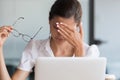 Stressed tired young business woman holding glasses feeling headache Royalty Free Stock Photo