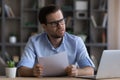 Stressed young businessman reading letter with bad news. Royalty Free Stock Photo