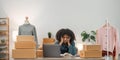 Stressed young entrepreneur African American woman and courier parcel box at home office. Small business owner, online Royalty Free Stock Photo