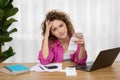 Stressed Young Female Checking Bills While Sitting At Desk In Home Office Royalty Free Stock Photo