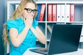 Stressed young girl in front of a computer screen. She accidentally deleted files.