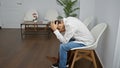 Stressed young hispanic man sitting in waiting room, exhaustion etched across his face as he awaits impending business meeting Royalty Free Stock Photo