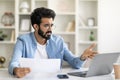 Stressed young indian man working with papers and laptop at home office Royalty Free Stock Photo